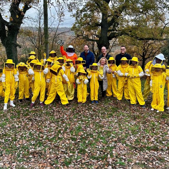 foto de grup d'escolars abillats com apicultors i tres adults