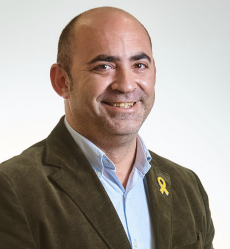 Jaume Sabaté, rgidor de Bot, imatge de tres quarts amb americana i llaç groc a la solapa