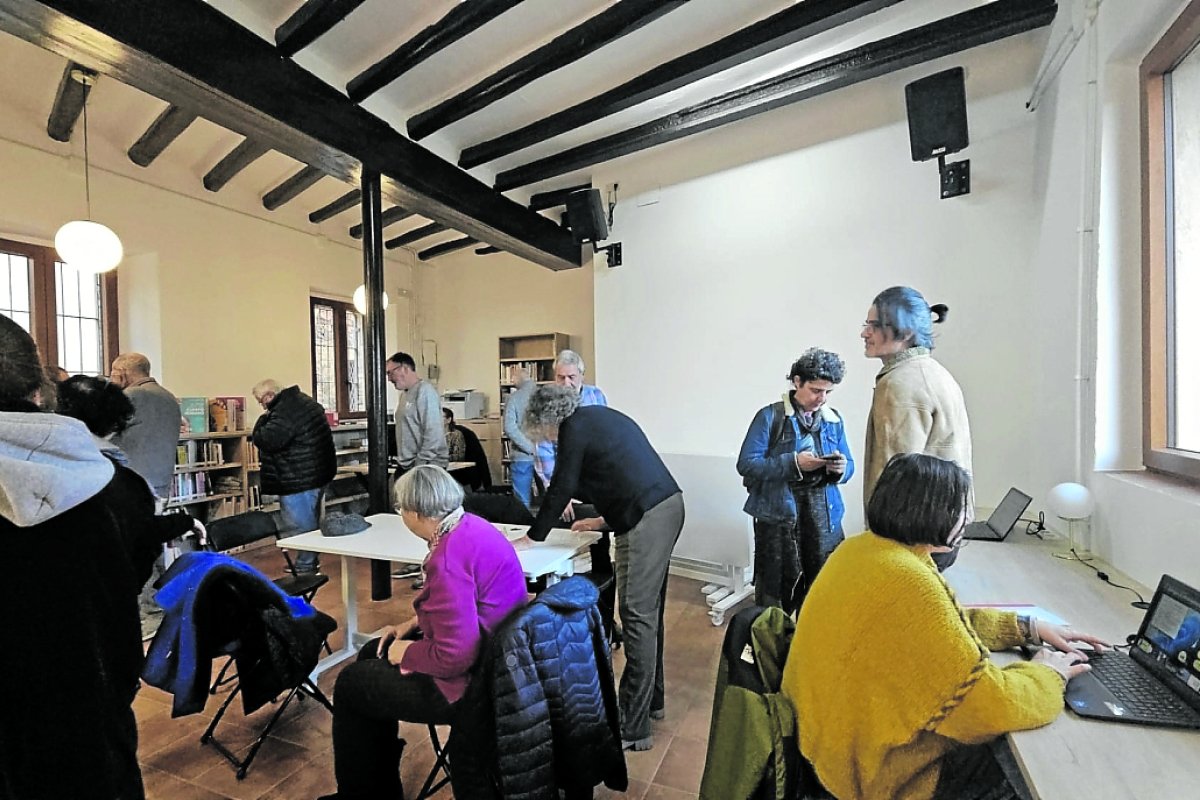 imatge d'una biblioteca a l'Argentera, amb persones lleguint i llibres